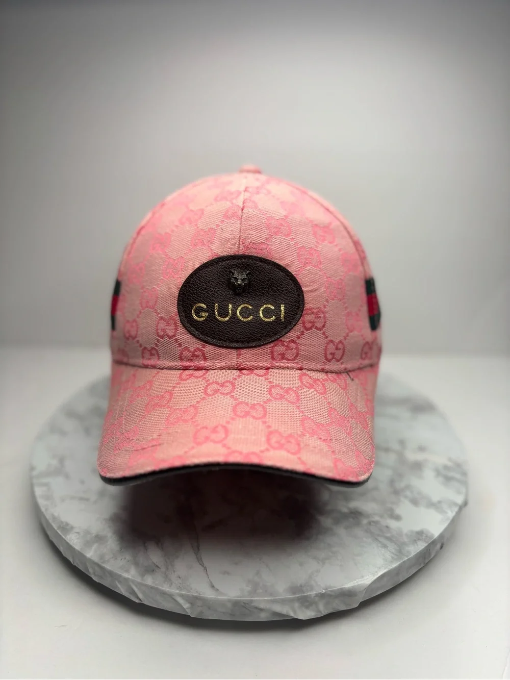 Gucci baseball cap featuring a pink GG monogram canvas and a leather patch